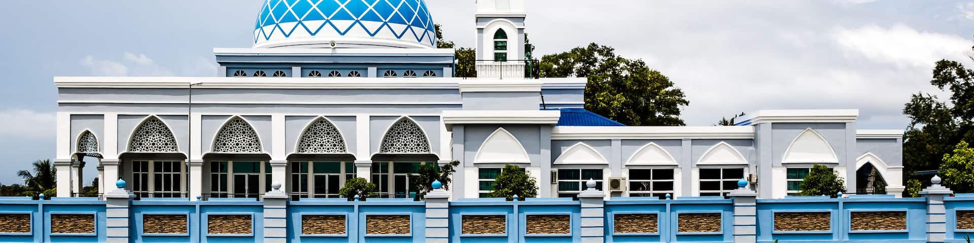 A mosque with a large blue dome and a tall minaret.