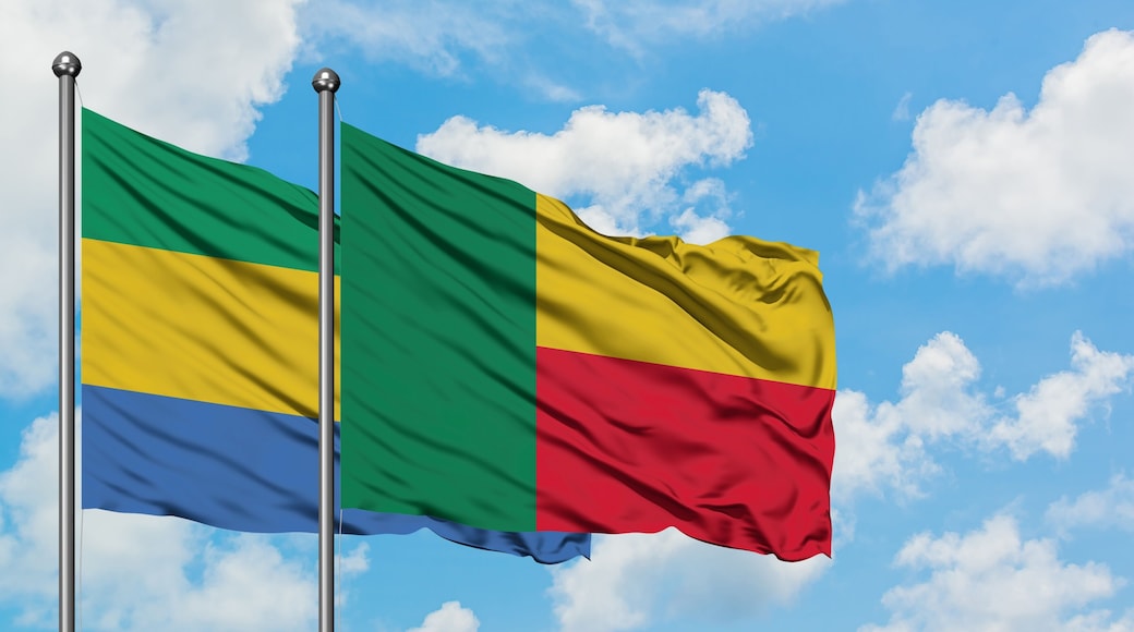 Gabon and Benin flag waving in the wind against white cloudy blue sky together. Diplomacy concept, international relations.