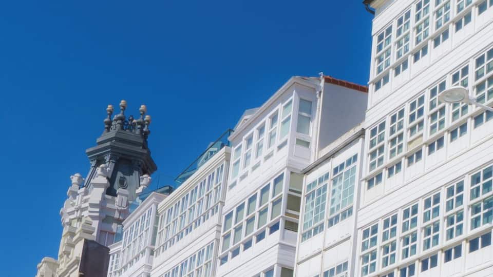 A white building with multiple windows and a clock tower.