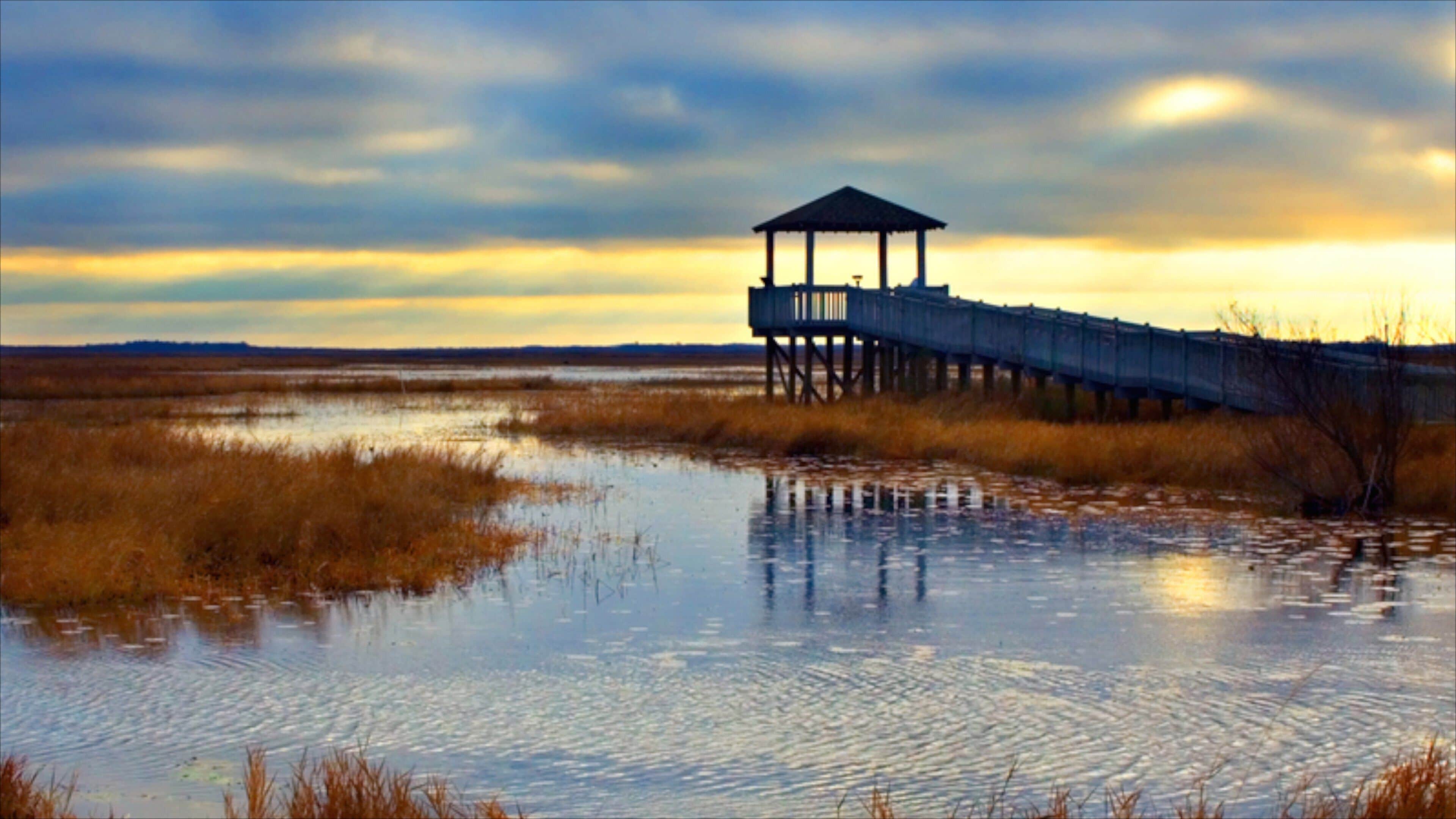 Lake Charles featuring a sunset, wetlands and views