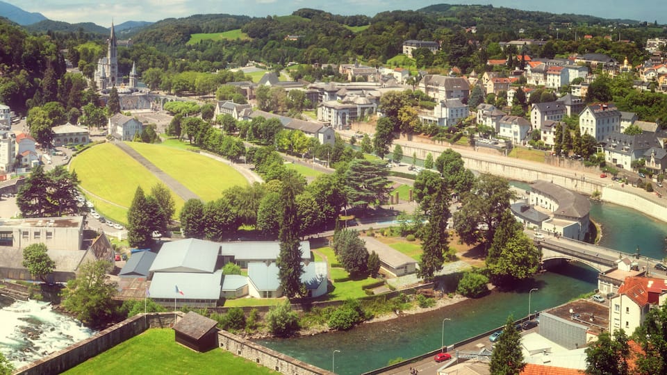 A riverside town with a prominent church, a football field, and a bridge.