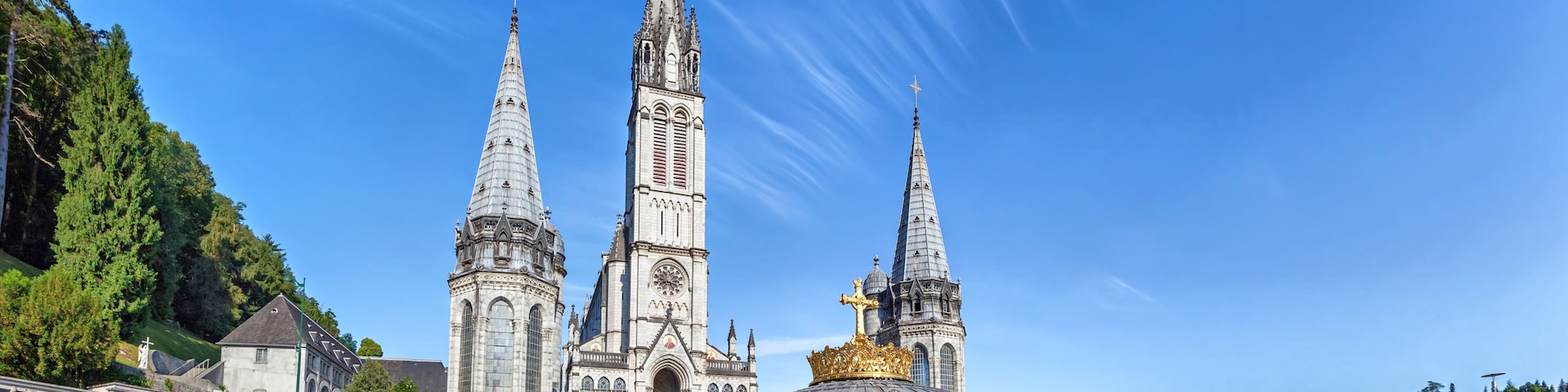 Una catedral con tres torres puntiagudas y una cúpula dorada.