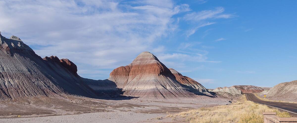 A rugged landscape with a prominent butte and a winding road.