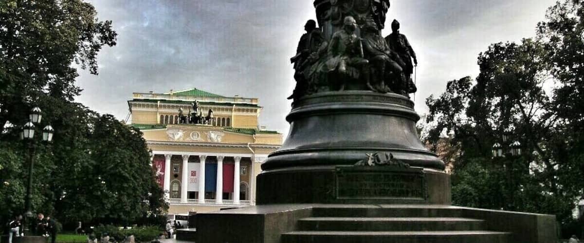 Source: http://www.saint-petersburg.com/monuments/catherine-the-great/
This monument to Catherine the Great was unveiled in 1873. The Empress was adored by the people of St. Petersburg for all her efforts to improve the life and education provided by the city and her reign has long seen been known as the "golden age" of Russia. The statue of Catherine is surrounded by delicately carved figures of the most prominent individuals of her reign: politicians and poets, military men and courtiers. The monument is located in the middle of a small, grass-covered square, just off Nevsky Prospekt, which is lined by the Anichkov Palace, the Alexandrinsky Drama Theater and the Russian National Library. As one of the country's most enlightened monarchs, Catherine could not have chosen a better spot herself.
The monument was designed by the Russian artist M.O. Mikeshin and created by the best sculptors and architects of the day. Catherine the Great is dressed in her official gown and holds a scepter in her right hand and an olive wreath in her left hand. The pedestal is decorated with the symbols of royal power. Among the dignitaries, who's likenesses have been carved on the statue's pedestal, are Alexander Suvorov, perhaps the most famous general in Russian history, Prince Potiomkin, the general and politician, Ekaterina Dashkova, the first woman to chair the Russian Academy of Sciences (in the 18th century!!!) and the celebrated poet Gavrila Derzhavin.
#architecture