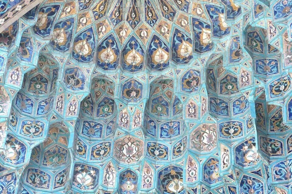 Eine detailreiche Mosaikdecke mit geometrischen Mustern und floralen Ornamenten.