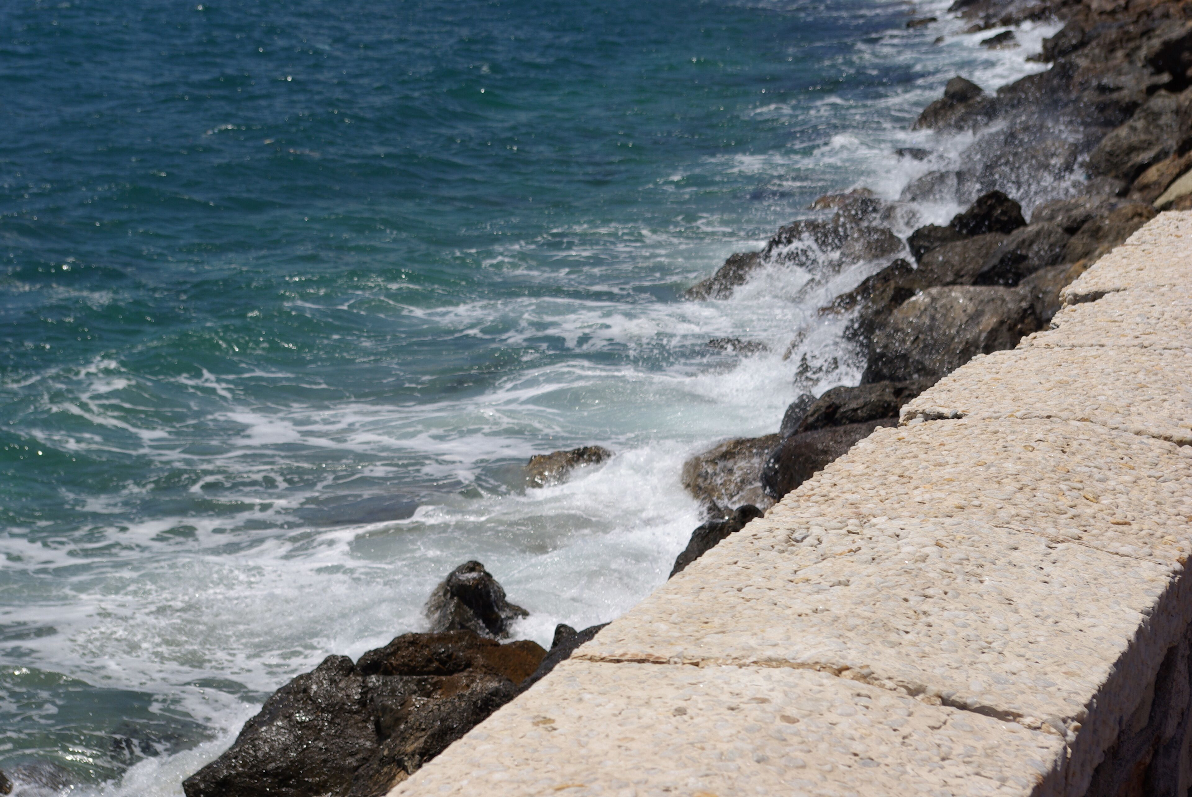 A rocky coastline with waves crashing against the shore.