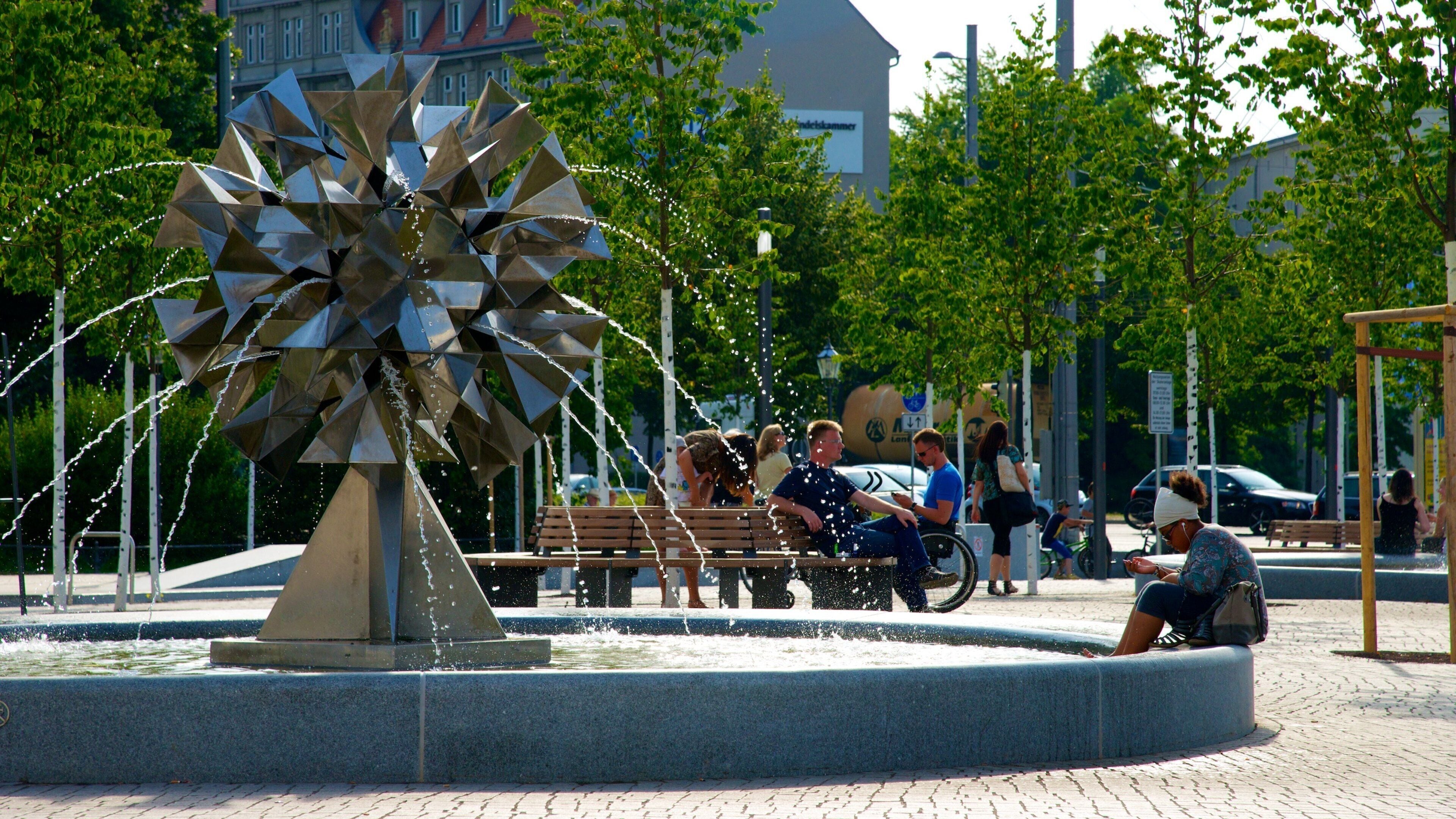 Leipzig which includes a square or plaza, a fountain and outdoor art
