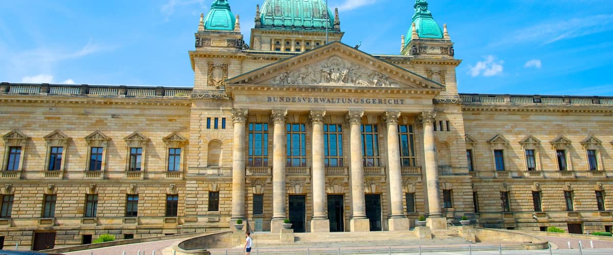 Un grand bâtiment historique doté d’un dôme imposant et de deux dômes plus petits, caractérisé par une architecture classique et des colonnes.