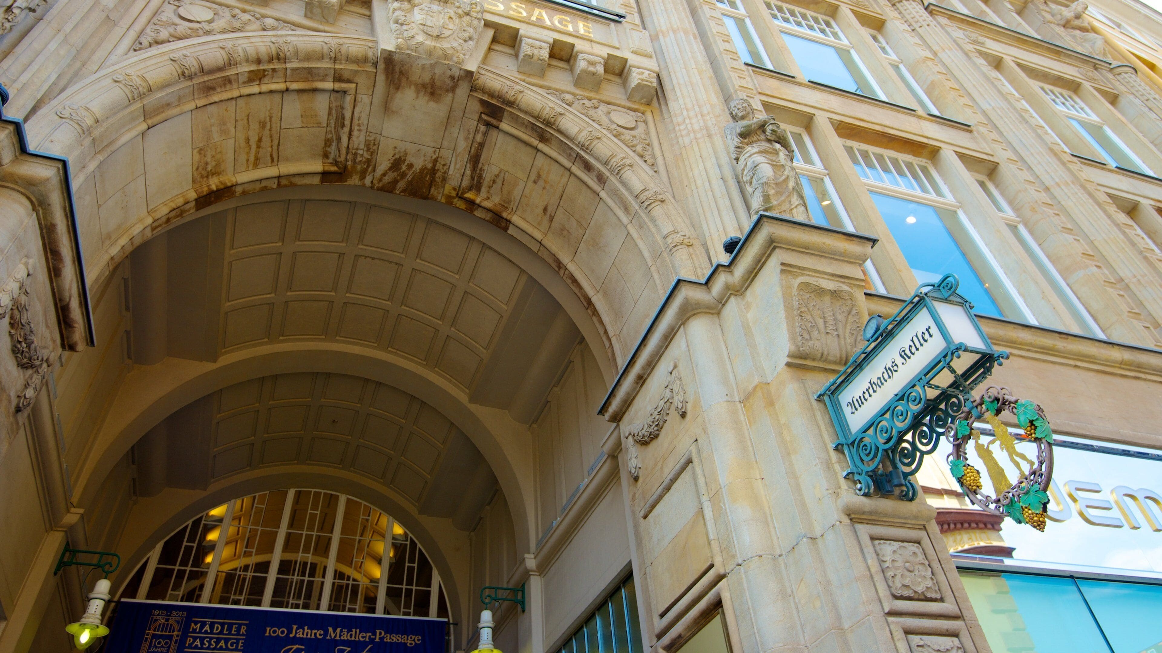 An ornate stone archway with a sign reading "Madder Passage" and a "100 Jahre Mädler-Passage" commemorating 100 years.