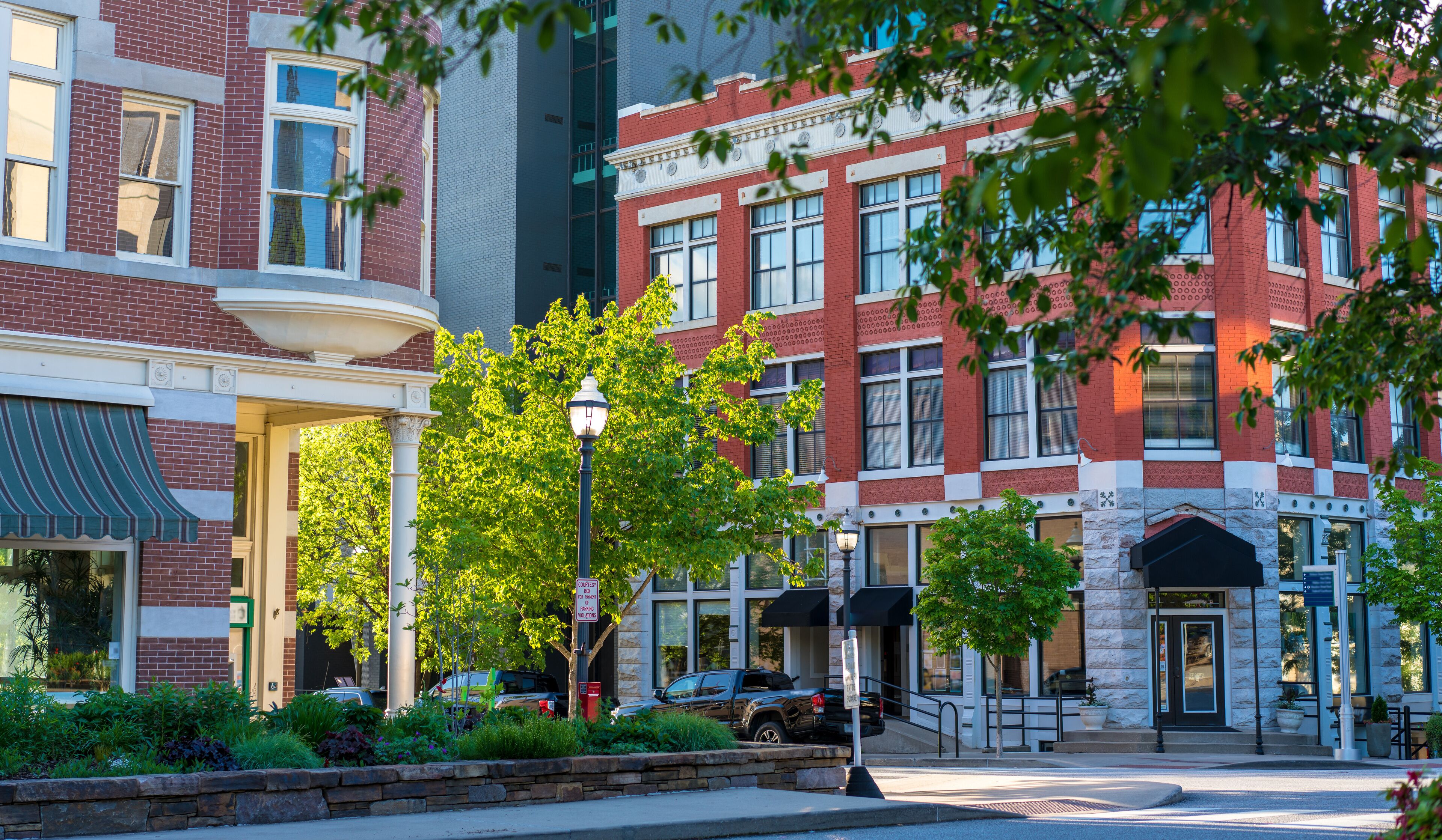A street lined with brick buildings, a lamppost, and a stone building entrance.
