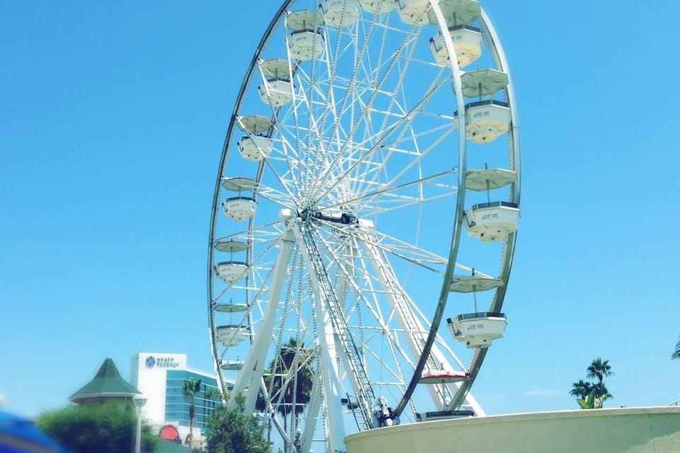 A large Ferris wheel with cabins labeled "Hyatt Regency" in the background.