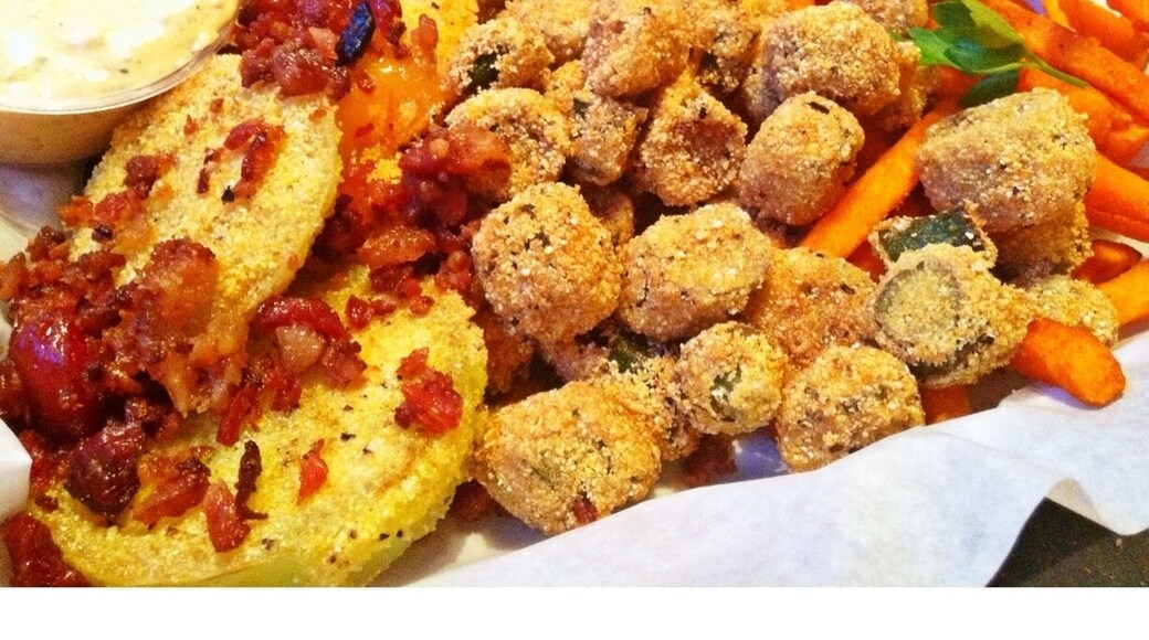 A part of the roadhouse feast dinner. Appetizer platter with fried green tomatoes, fried okra and sweet potato fries followed by smoked meats, sides and peach cobbler.