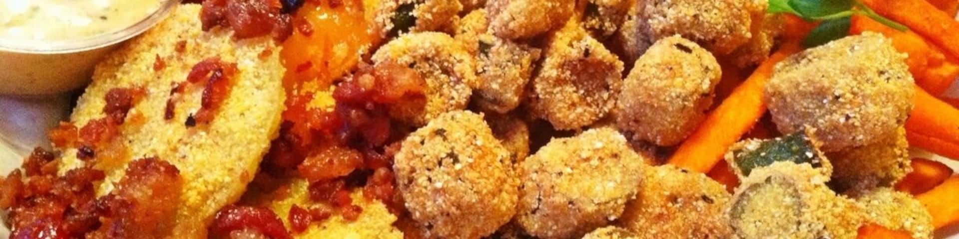 A part of the roadhouse feast dinner. Appetizer platter with fried green tomatoes, fried okra and sweet potato fries followed by smoked meats, sides and peach cobbler.