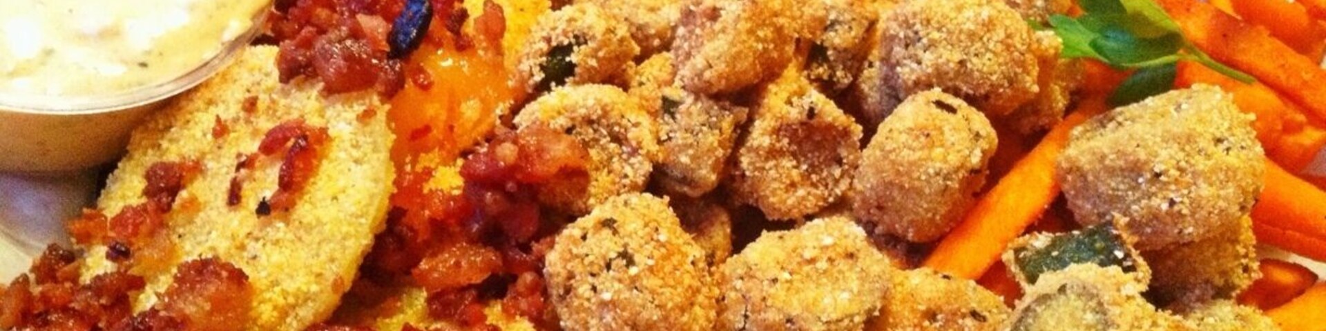 A part of the roadhouse feast dinner. Appetizer platter with fried green tomatoes, fried okra and sweet potato fries followed by smoked meats, sides and peach cobbler.