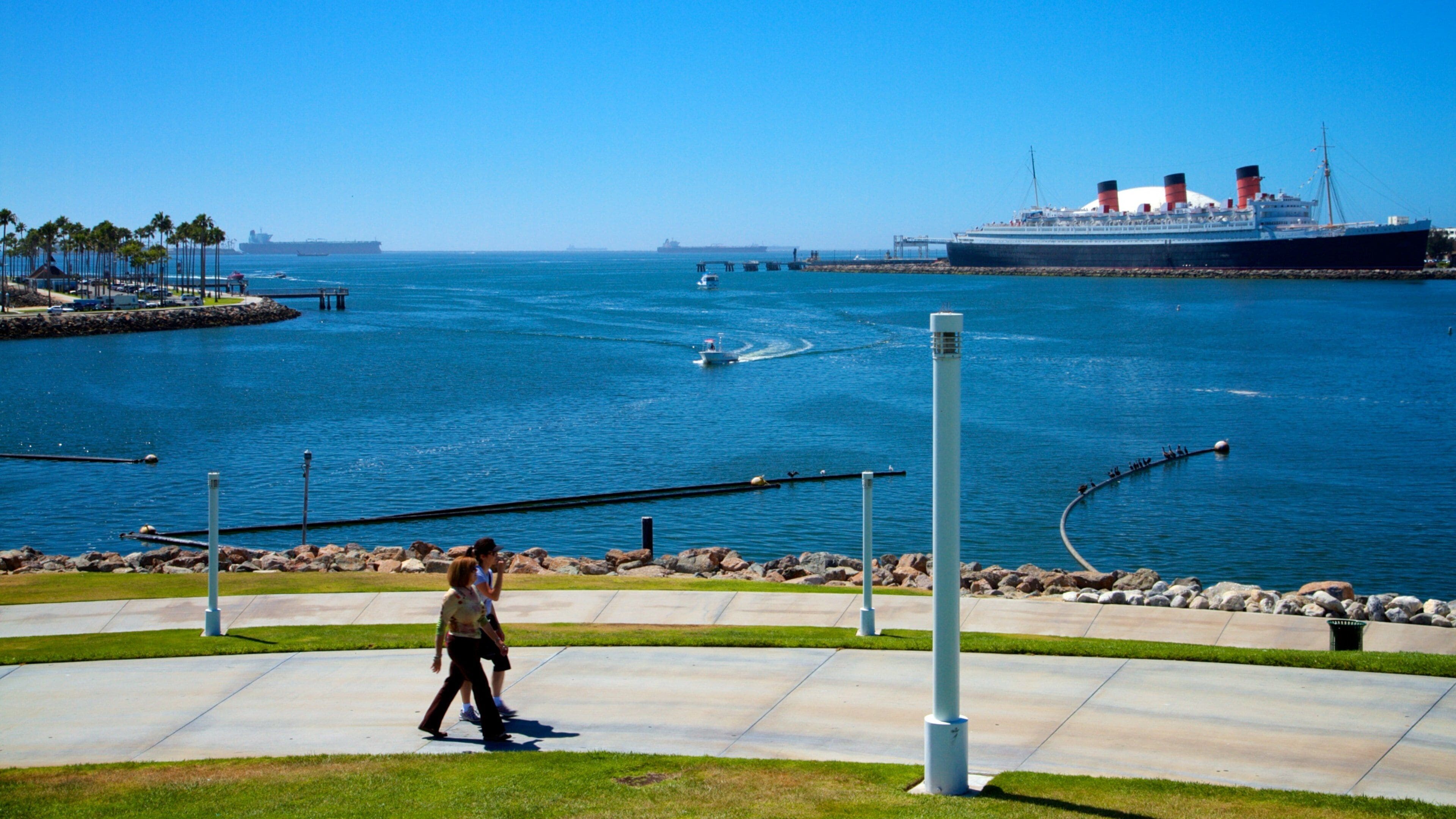 Un paseo marítimo con un gran crucero al fondo.