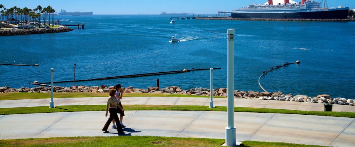 A coastal walkway with a large cruise ship in the background.