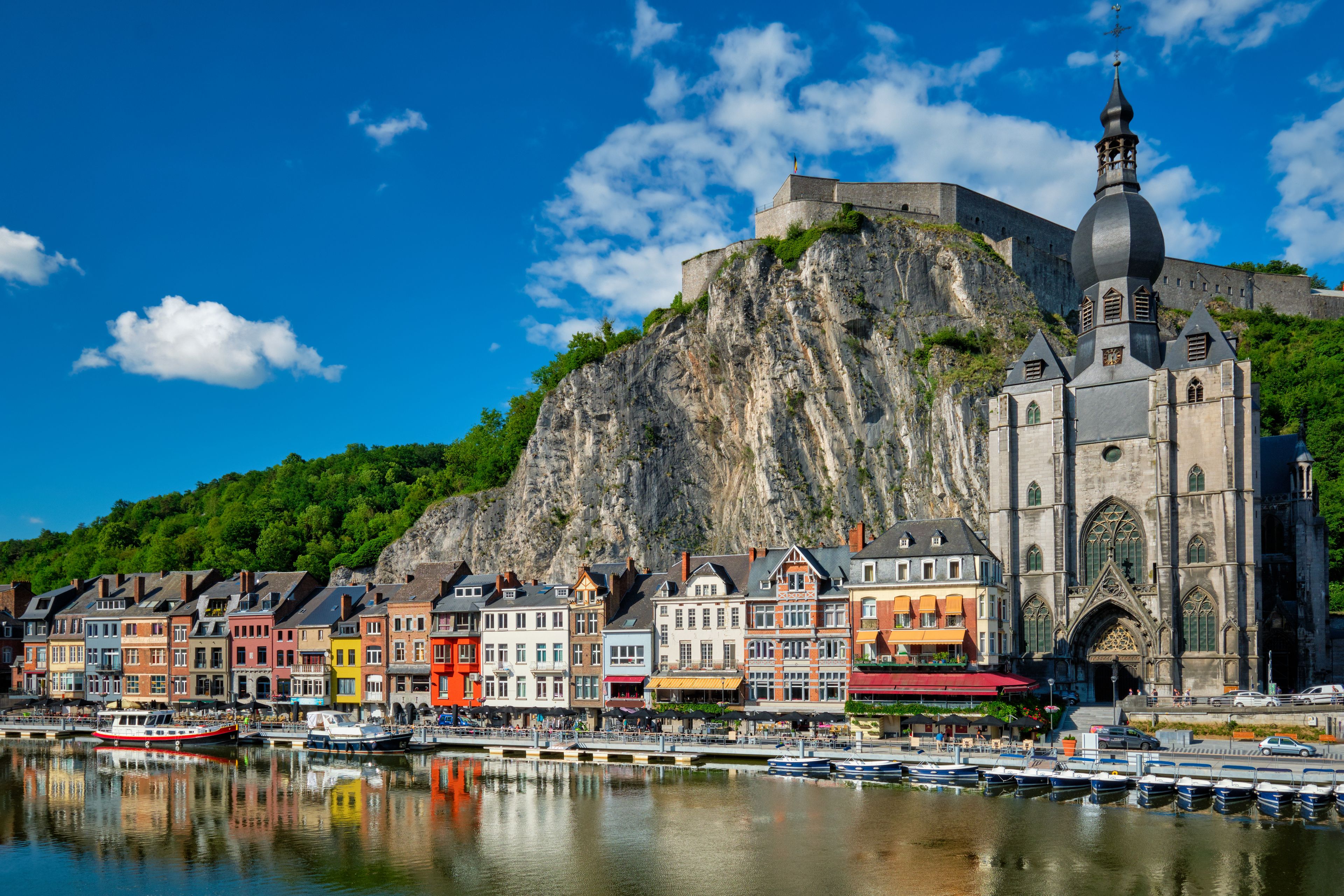 A historic town with colorful buildings, a church, and a large fort on a hill.