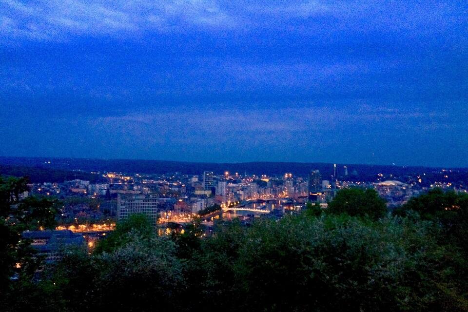 En stadsbild i skymningen med en flod och broar.