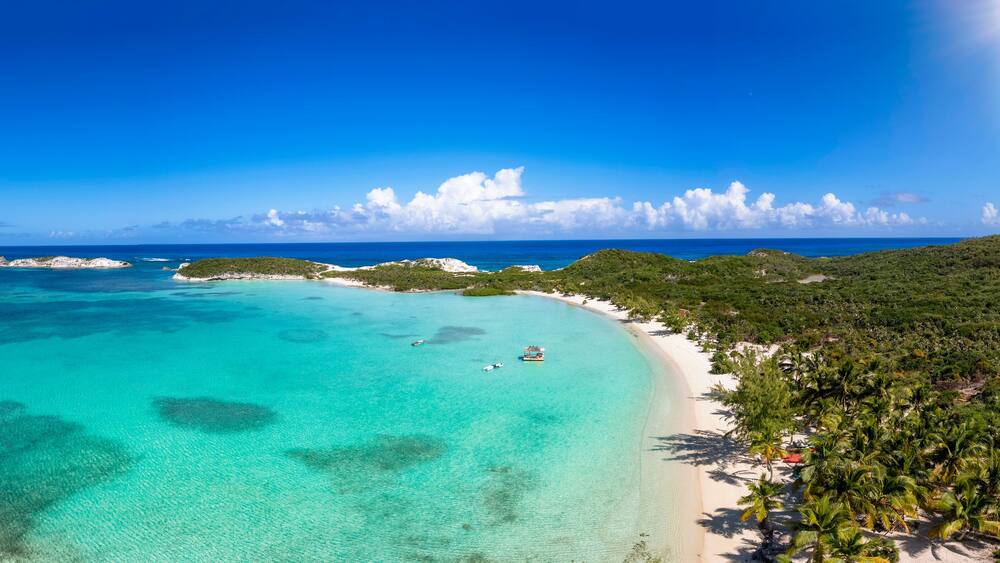 The beautiful Stingray Beach at the north of Long Island, The Bahamas, with tropical palm trees and turquoise sea