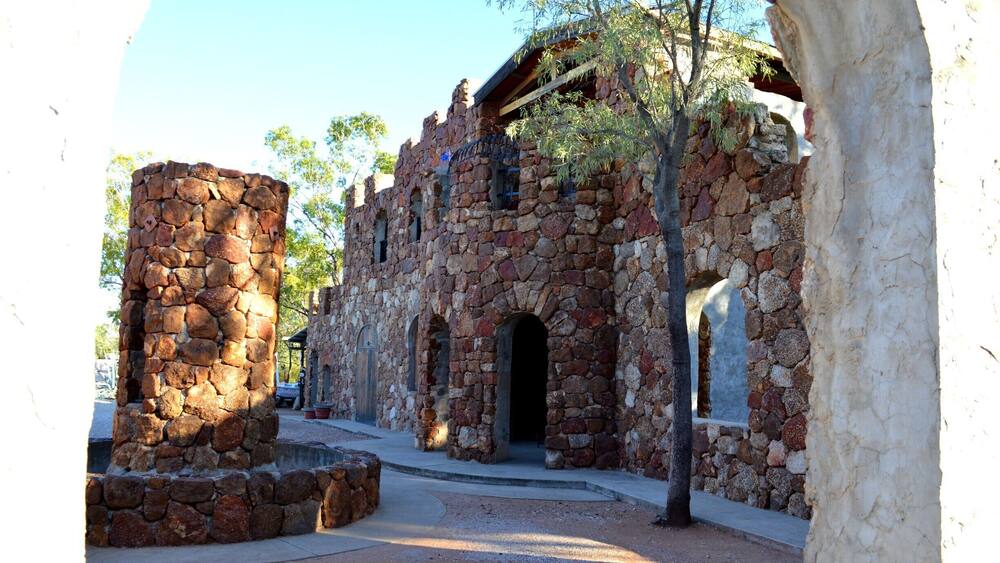 A historic stone building with arched windows and a stone tower.
