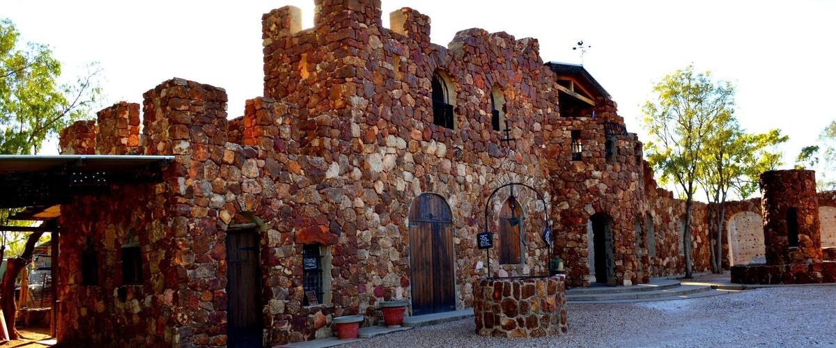 Un edificio histórico de piedra con ventanas arqueadas y una puerta de madera.
