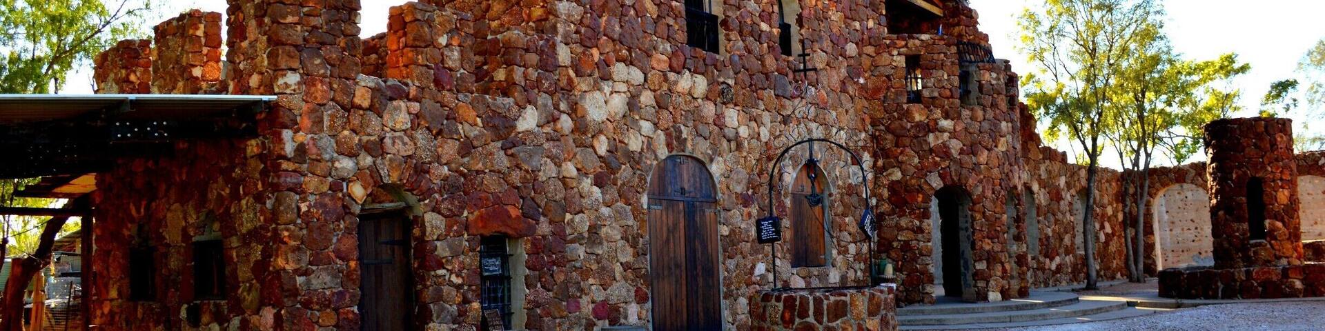 A historic stone building with arched windows and a wooden door.
