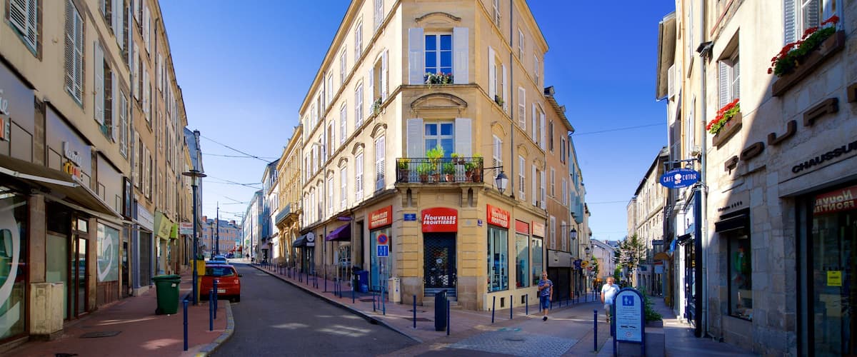 A street with buildings, a cafe, and a red car.