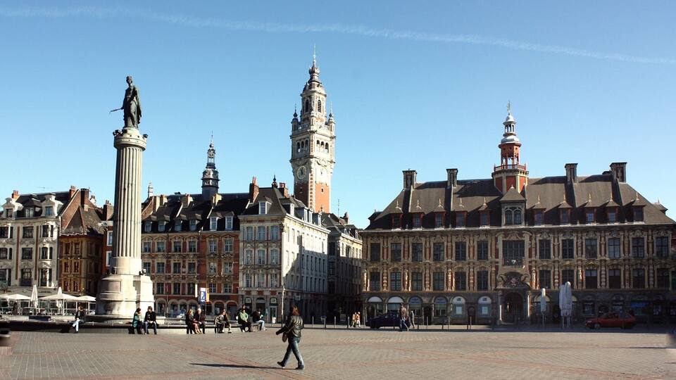 Ein historischer Platz mit einer markanten Statue, einem Glockenturm und prächtigen Gebäuden.