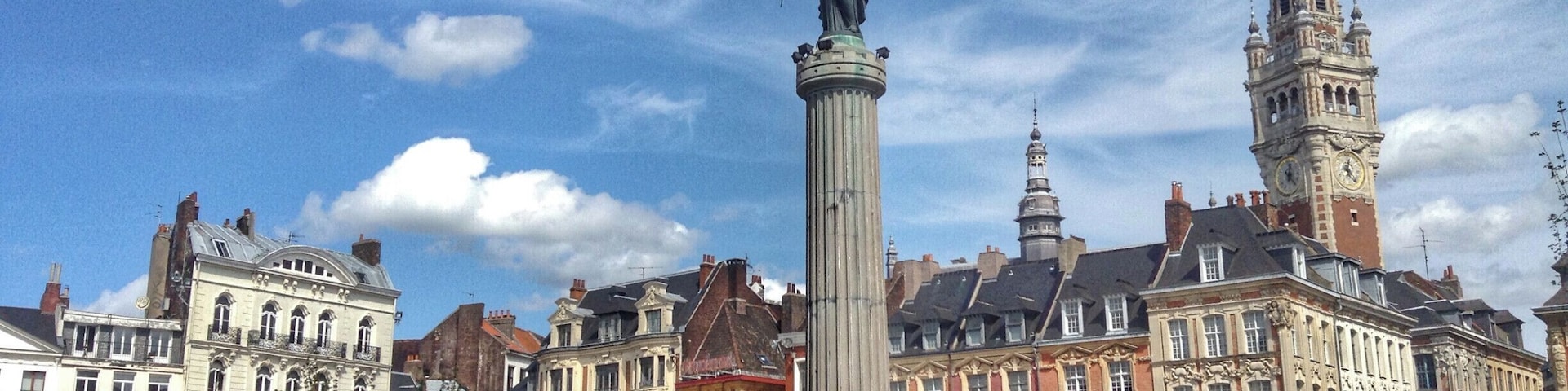 A bustling square with a prominent monument, historic buildings, and a clock tower.