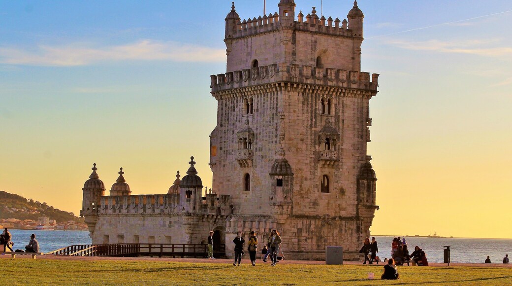 I took this in March at Belém Tower, in Lisbon, Portugal. And came at just the right time - sunset time! And yet there were still quite a few people lazying about :). It was a beautiful Spring day there!
This fortified tower is a UNESCO World Heritage Site and one of the most iconic sites in Lisbon! Built in the early 16th-century, it played a significant role in the Age of Discoveries. The tower was commissioned by King John II to be part of a defense system at the mouth of the Tagus river and a ceremonial gateway to Lisbon. The structure was built from Lioz limestone and is composed of a bastion and a 30 m (98.4 ft),four storey tower. It's impressive to see in person! Thanks to Wikipedia for the info, as well ;).