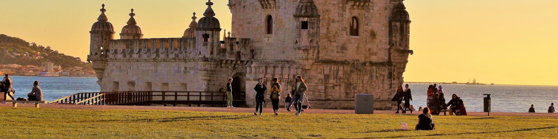 I took this in March at Belém Tower, in Lisbon, Portugal. And came at just the right time - sunset time! And yet there were still quite a few people lazying about :). It was a beautiful Spring day there!
This fortified tower is a UNESCO World Heritage Site and one of the most iconic sites in Lisbon! Built in the early 16th-century, it played a significant role in the Age of Discoveries. The tower was commissioned by King John II to be part of a defense system at the mouth of the Tagus river and a ceremonial gateway to Lisbon. The structure was built from Lioz limestone and is composed of a bastion and a 30 m (98.4 ft),four storey tower. It's impressive to see in person! Thanks to Wikipedia for the info, as well ;).