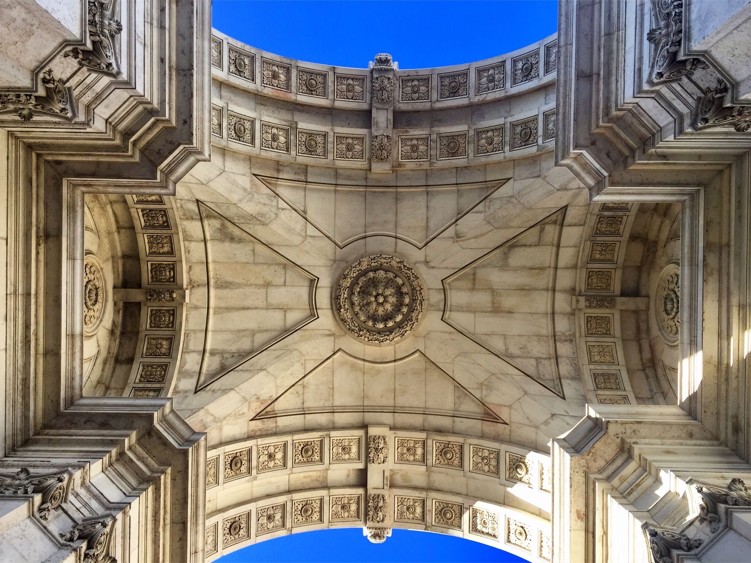 A grand architectural structure with intricate carvings and a central circular design.