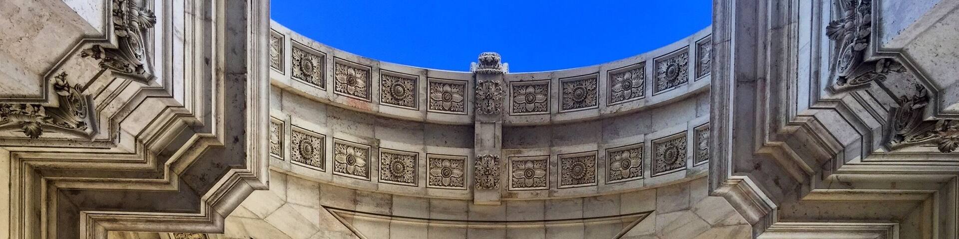 A grand architectural structure with intricate carvings and a central circular design.