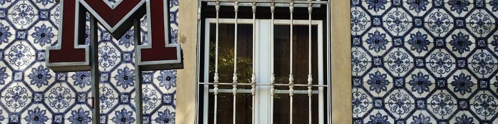 Subway entry in Lisbon in front of one ot the many tiled-covered buildings.