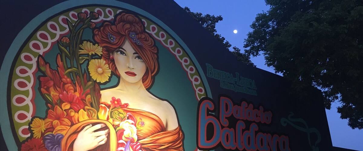 Un mural que muestra a una mujer sosteniendo flores, con el texto 'Palacio Baldorioty de Carvalho' y el año '1840'.