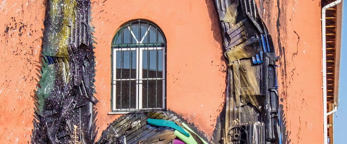 A building with a colorful mural of a lion made from various objects.