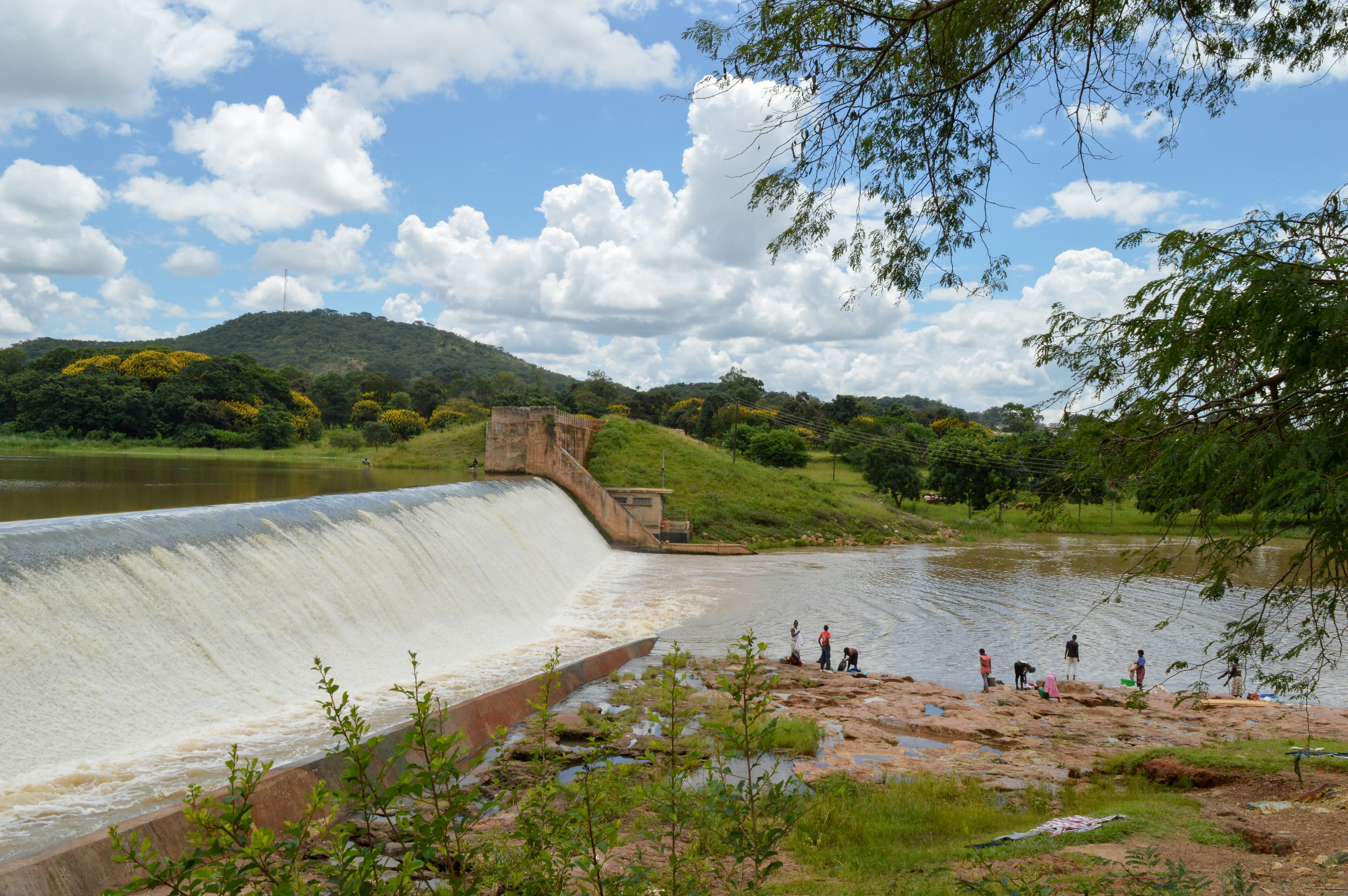 Amazing lanscape with small waterfall. African people are washing clothes near Kamuzu dam in Lilongwe, Malawi - in one of the poorest countries ath the world
