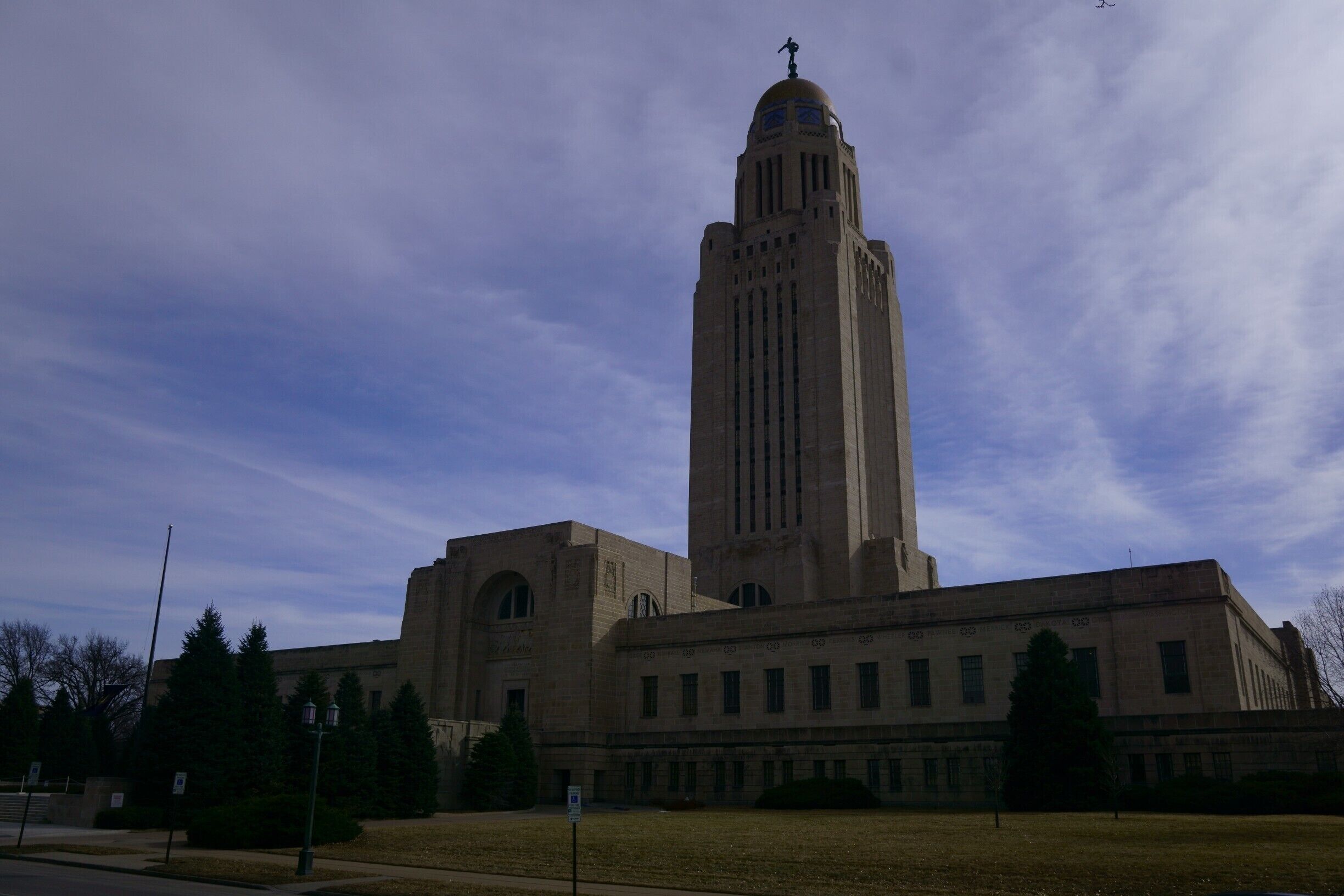 Clad with Indiana limestone, the Capitol has a low, wide base in the plan of a “cross within a square”, creating four interior courtyards. Tower stands 400' domed tower with a 19 foot tall bronze figure of “The Sower”.