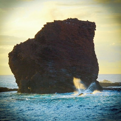 Behold... Puu Pehe, known as “Sweetheart Rock”. 
This is Lanai’s most notable landmark and the setting for one of Hawaii’s epic legends.
Story goes a hottie princess from Maui was "captured" by a young warrior from Lanai. He made her his wife and he was so smitten with her beauty and... apparently so insecure that he was afraid to let other men see her so kept her in a sea cave near the rock when he was away. One day the weather suddenly changes, the surf slams the area, and... yup, one less princess. The warrior rushed back to the cave, but it was too late, he climbed the steep rock where he buried her in a tomb and then overcome with grief leapt to his death.
Moral of story might be... um, don't abduct women and lock them in caves.