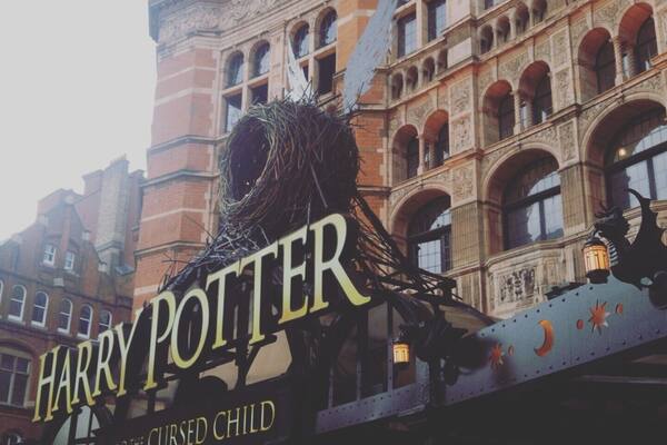 Un bâtiment à l’architecture riche et travaillée, sur lequel on peut lire l’inscription « Harry Potter et l’enfant maudit ».