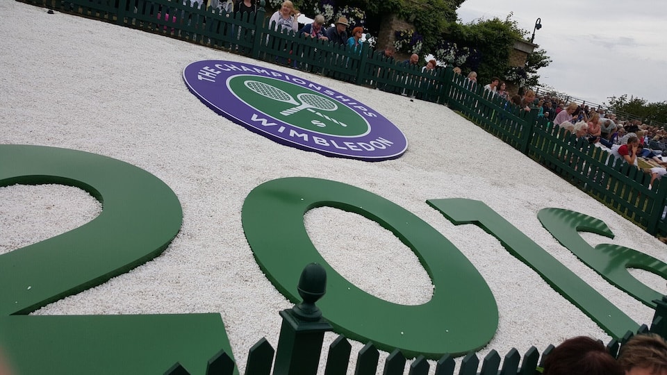 A tennis court with the Wimbledon logo and the year 2016.