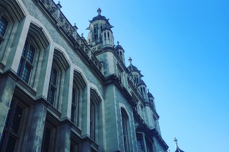 Um edifício histórico com arquitetura ornamentada, incluindo janelas amplas e pináculos decorativos.