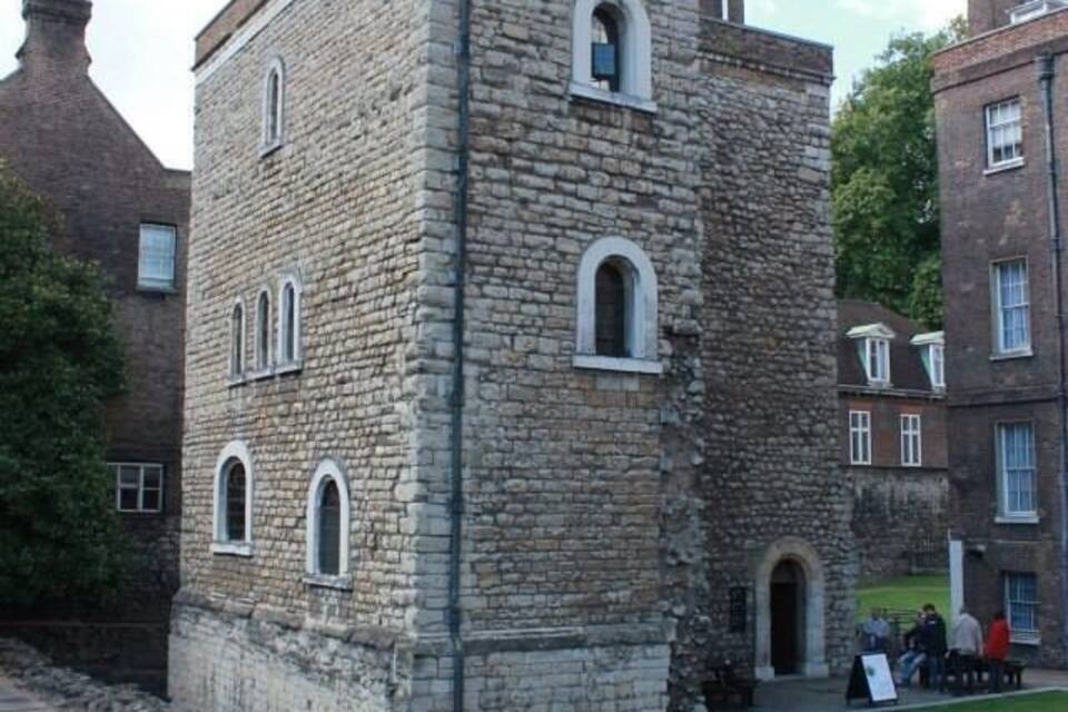 A stone building with arched windows and a flag on top.
