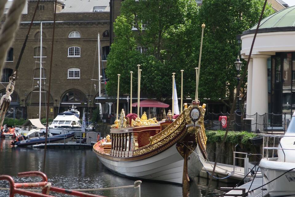 Ein traditionelles Boot liegt im Hafen vor einem Kirchturm.