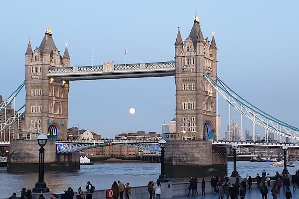 Die Tower Bridge in London mit dem Mond am Himmel.