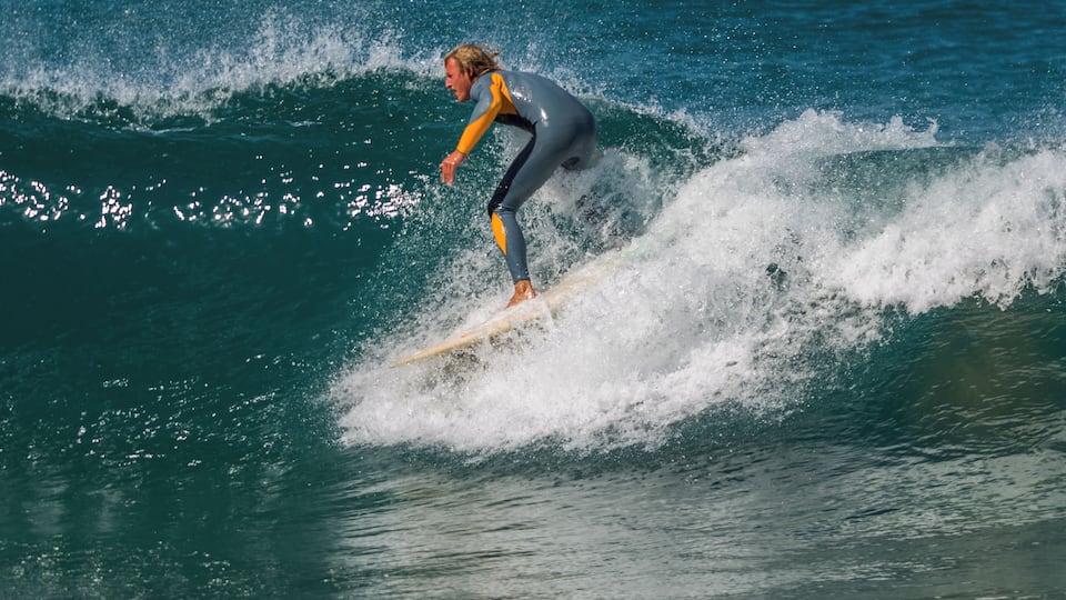 A person surfing a wave in the ocean.