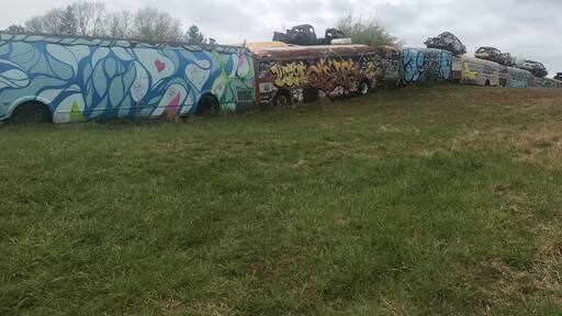 The painted school buses form a fence around a junk yard. Be aware that you just park along the road and go up the hill to get there. I think you can tour the yard but it’s only open mon - fri 8-5 pm.