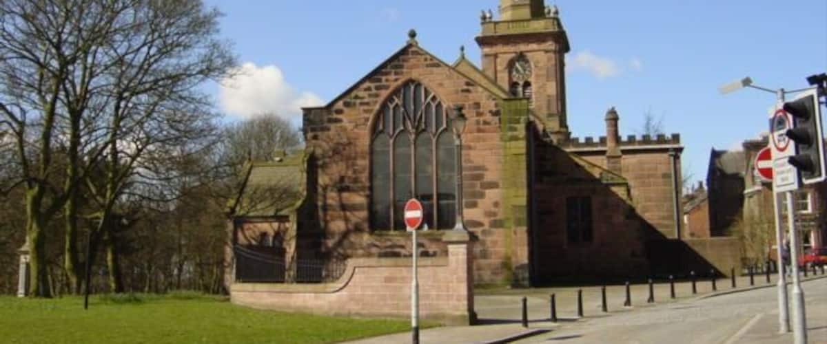A historic church with a tall spire and large arched windows.