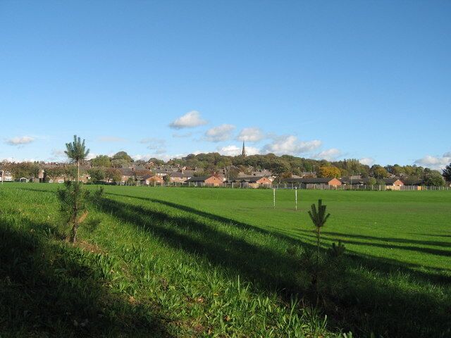 Prescot from Carr Lane Playing fields Looking over the playing fields bordered by Carr Lane and Wood Lane to the spire of St Mary's church, Prescot. In the foreground, recently planted saplings along the new cyclepath on Carr Lane which was once a dead end (and a bit of a lover's lane!) but has recently been opened as a bypass and access road for the busy Cables Retail Park. A car park has been provided for the fishing pond and the whole area given a new lease of life.