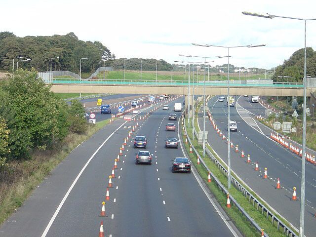M62 at Tarbock Island View eastwards from the roundabout level. The bridge visible was built to carry the branch railway from Cronton Colliery.